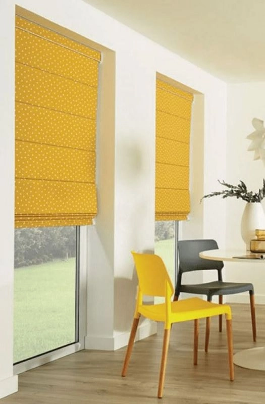 Stylish yellow patterned roman blinds in Dubai dining area.